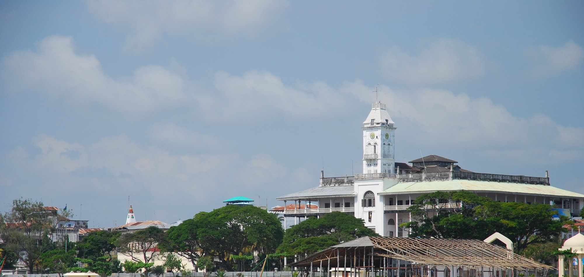 Stone Town's seafront skyline from the water, the clock tower of the House of Wonders (closed for reconstruction) rising behind the trees, Zanzibar's UNESCO-listed old city.
