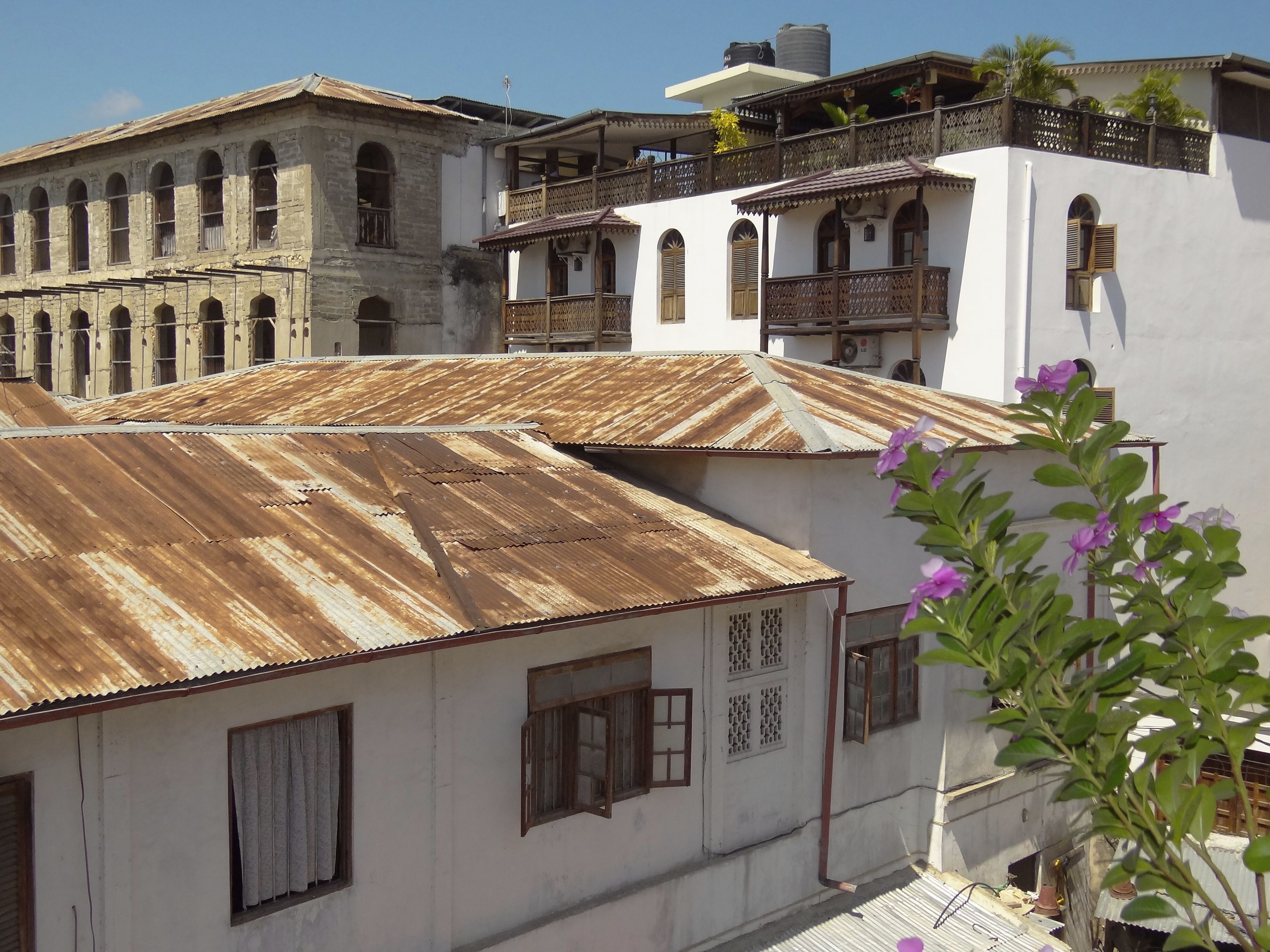 A rooftop view across Stone Town's corrugated-iron roofs to carved wooden Swahili balconies, Zanzibar.